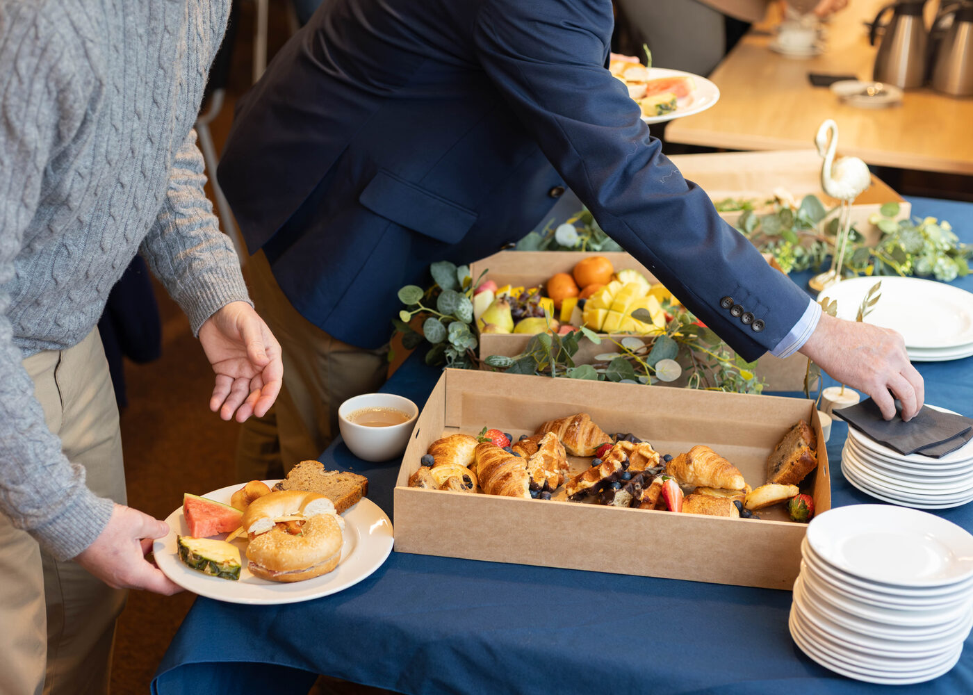 Colleagues serving themselves from Graze in the Bay breakfast catering boxes at a corporate away day