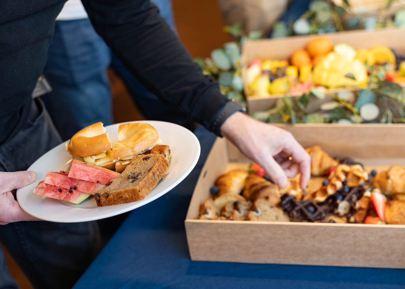 Guest serving themselves brunch from Graze in the Bay catering boxes at a Torbay business event