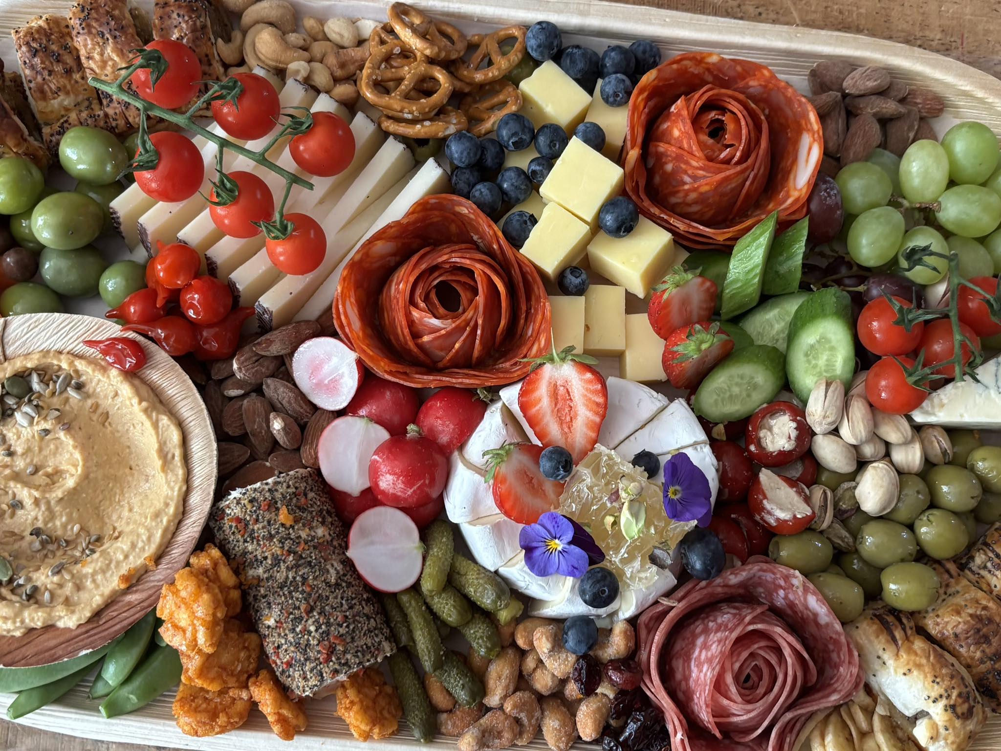 Luxury tiered charcuterie board with brie, prosciutto and berries