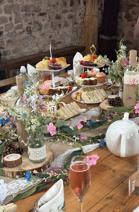 Afternoon tea table with scones, cupcakes and champagne in a barn venue