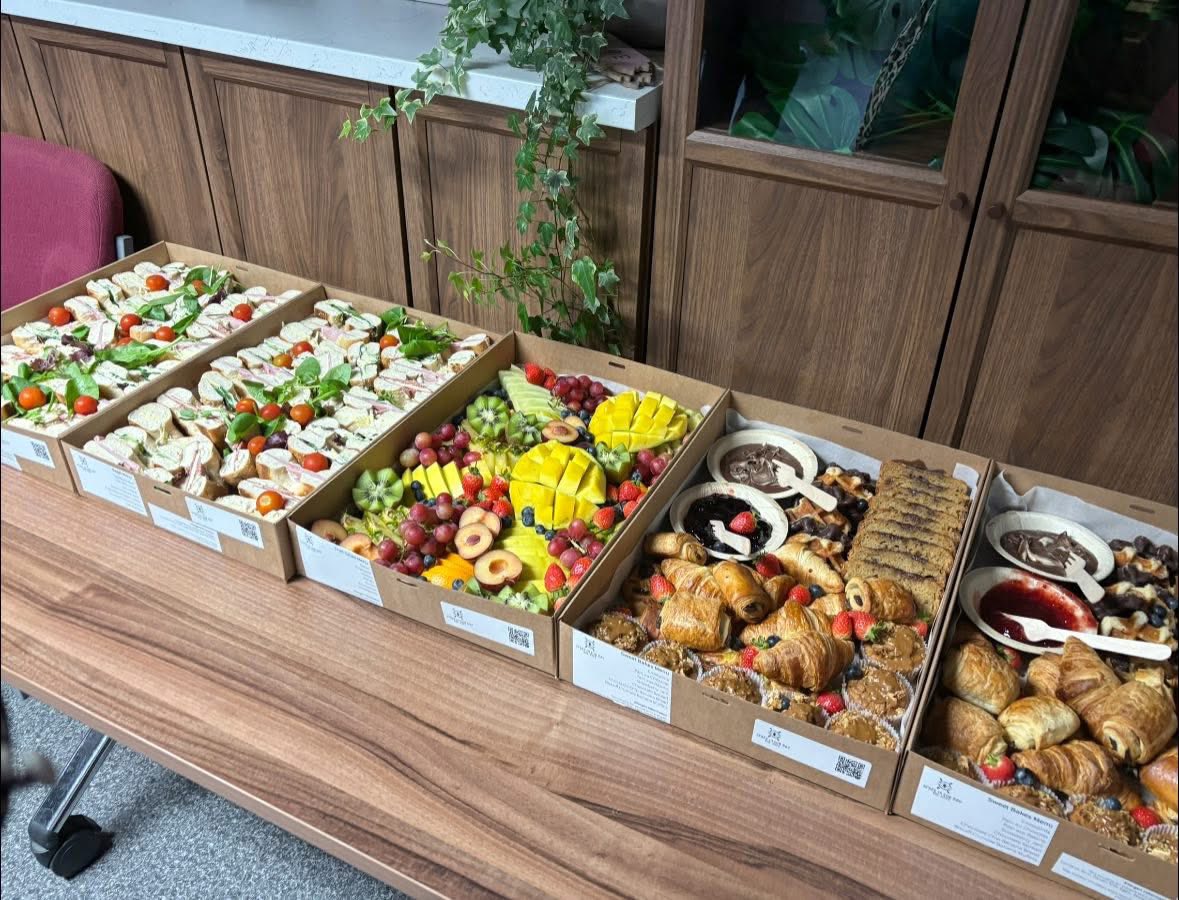 Individual corporate catering boxes lined up on an office table