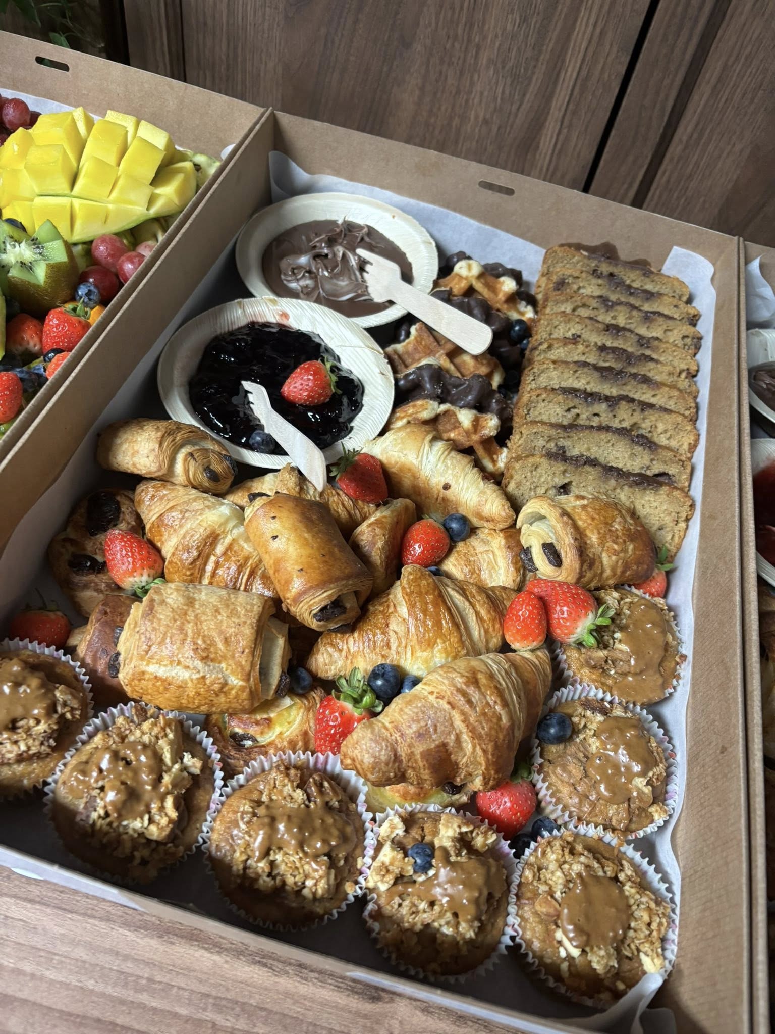 Brunch box with croissants, pastries, muffins and fresh berries